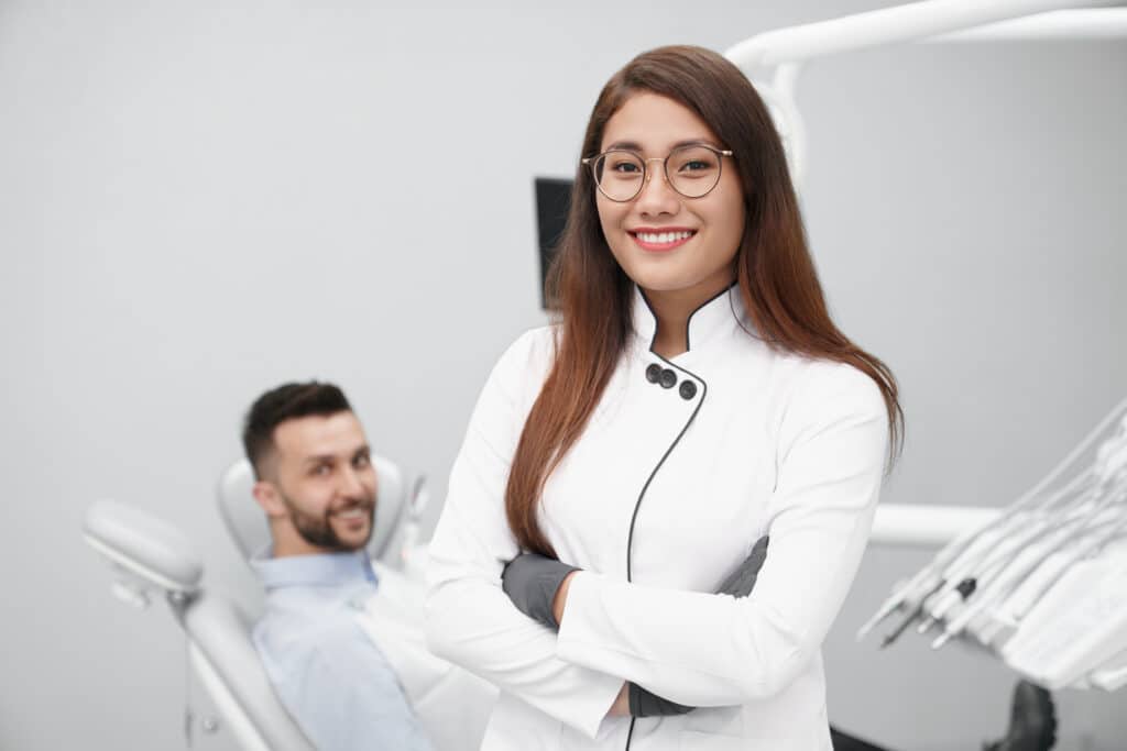 female dentist smiling in lab coat